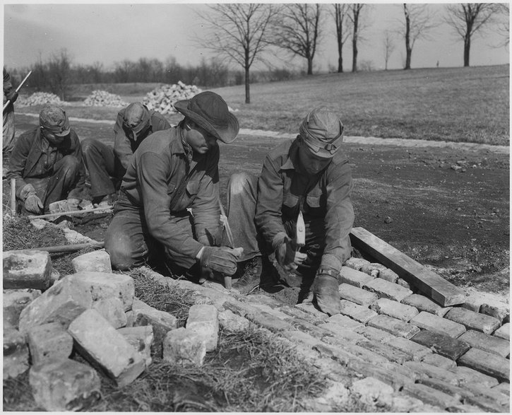 Pracownicy CCC budujący drogę. W 1933 r. ponad 3 miliony bezrobotnych młodych mężczyzn w USA zostało umieszczonych w ponad 2600 zakładach pracy zarządzanych przez CCC