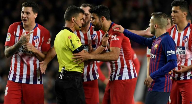 Atletico Madrid's Spanish forward Diego Costa confronts referee Gil Manzano during the Spanish league match against Barcelona