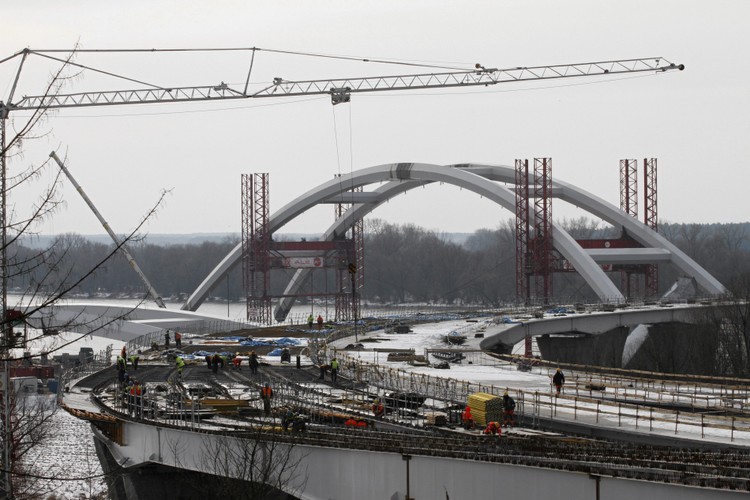 Pierwsze dwie części łuku przęsła nr 1, który będzie się znajdował po prawej stronie Wisły, zostały scalone w listopadzie 2012 roku. Następnie przesunięto je w miejsce, gdzie zostały wykonane baseny umożliwiające wpłynięcie pontonów.