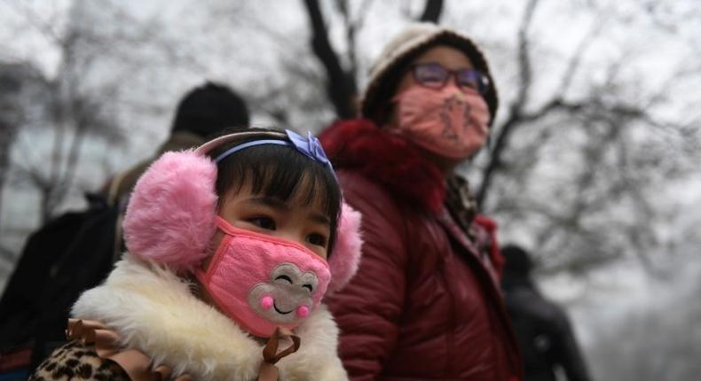 A young girl waits to cross a road in Shijiazhuang on December 21, 2016