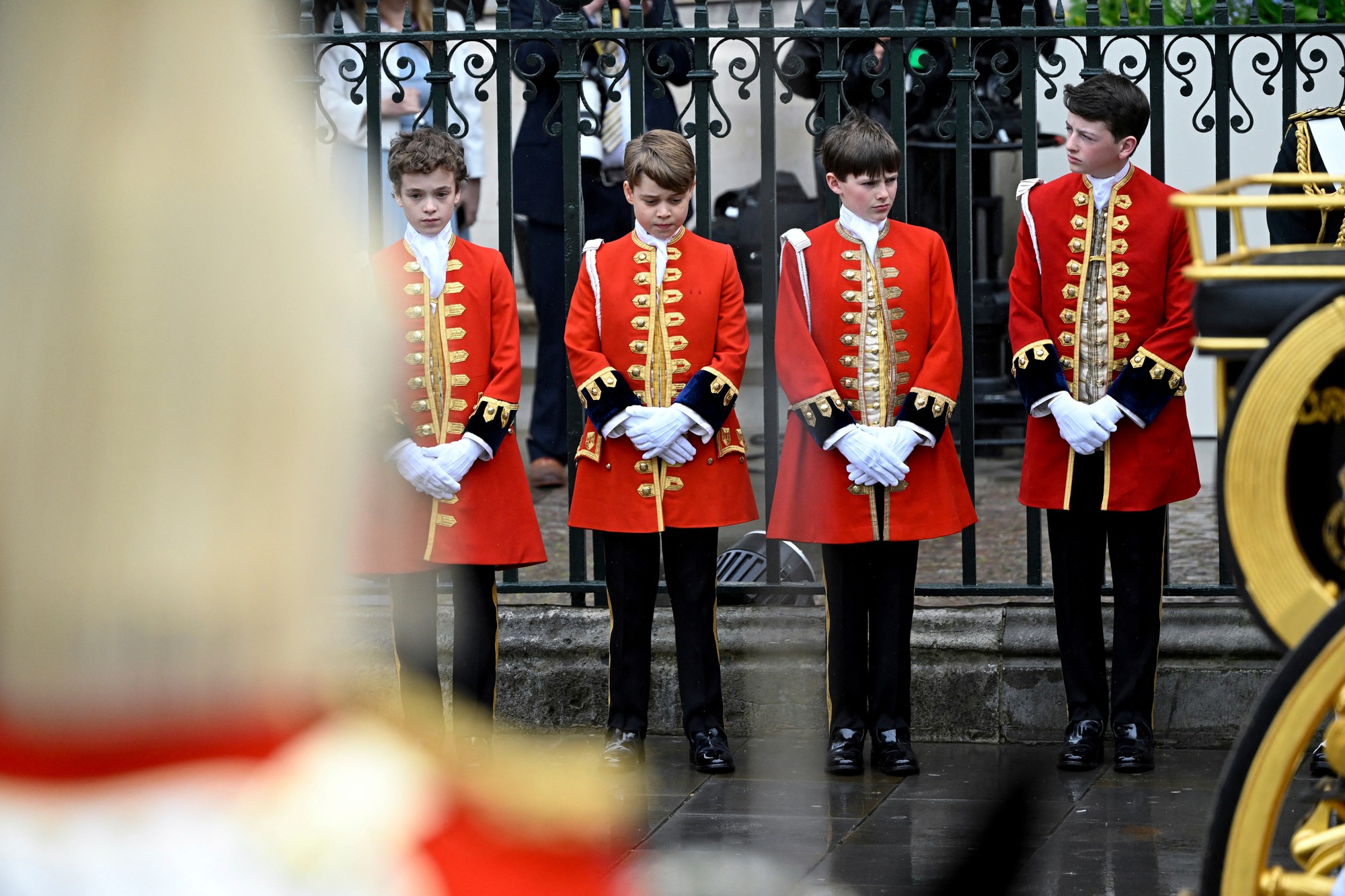 Britský princ George (druhý zľava) prichádza na slávnostnú korunováciu britského kráľa-