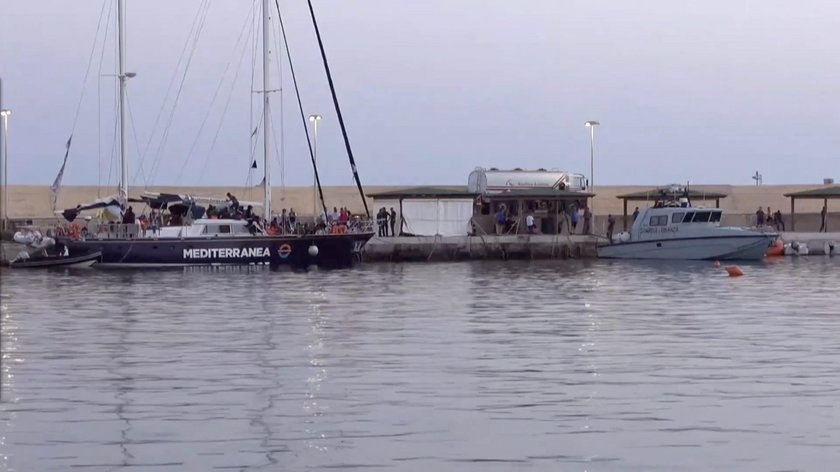 A still image from a video footage shows migrants sitting on board of a migrant rescue boat "Alex", 