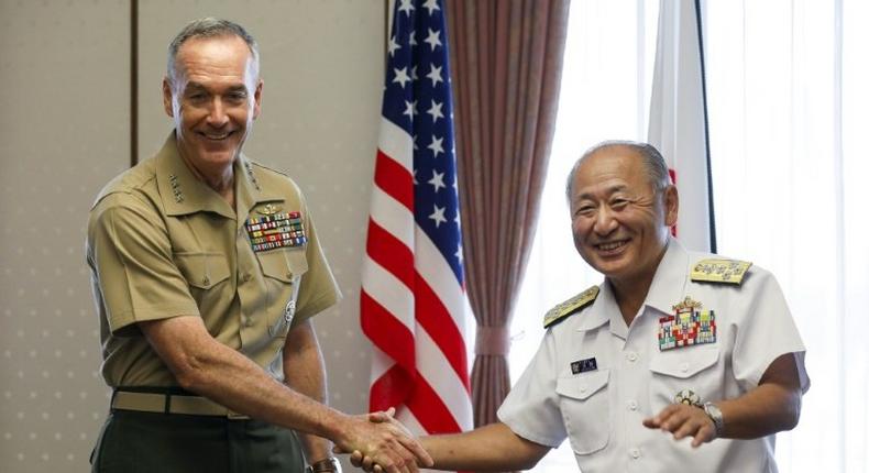 General Joseph Dunford (L), the chairman of the US Joint Chiefs of Staff, shakes hands with Japan's Chief of Staff of Joint Staff Katsutoshi Kawano (R) at the start of their talks at the Defence Ministry in Tokyo