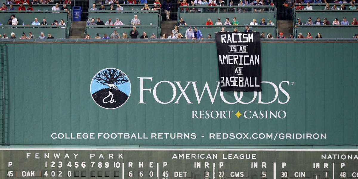 Protesters draped a banner on Fenway Park's Green Monster that read, 'Racism is as American as baseball'