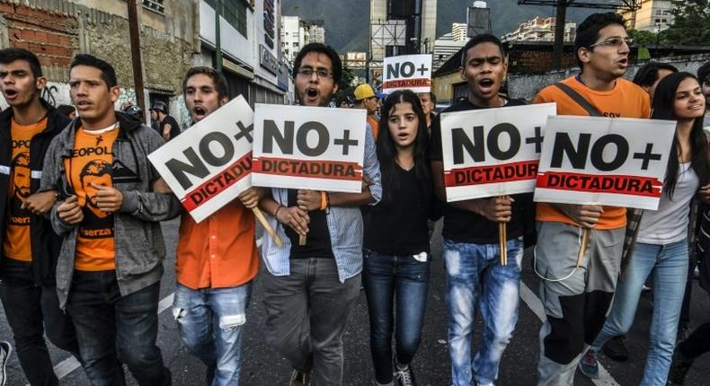 Opposition demonstrators march towards the Organisation of American States (OAS) headquarters in Caracas on June 21, 2017, after the 47th OAS General Assembly taking place in Cancun, Mexico, ruled out issuing a resolution on Venezuela