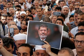 A man holds a picture of the former Egyptian president Mursi during a symbolic funeral prayer in Istanbul