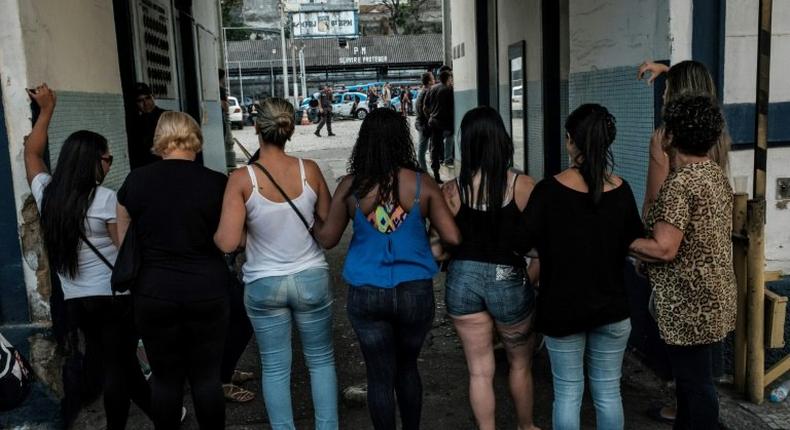 Wives and widows of military policemen block the entrance to the military police station in Rio de Janeiro on February 10, as they demand back pay for their relatives