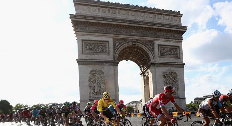 Chris Froome, in yellow, and the peloton ride past the Arc de Triomphe during stage 21 of the 2016 Tour de France, on the Champs-Élysées, July 24, 2016.