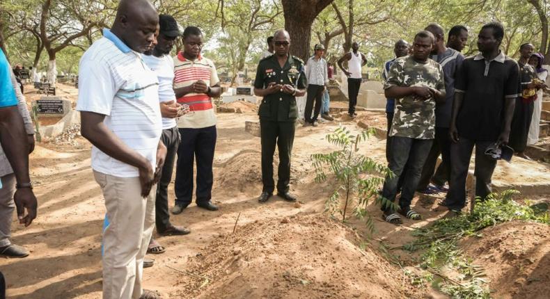 Mourners stand beside the grave of slain Ghanaian investigative journalist Ahmed Husein Suale who was gunned down in January as he returned to his home in Accra