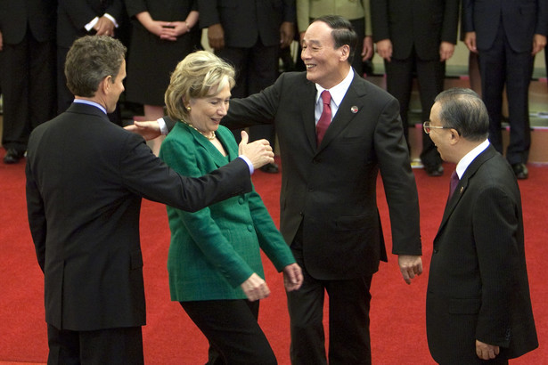 Hillary Clinton, amerykańska sekretarz stanu „schwytana” przez witających się od lewej Timothego Leithnera, amerykańskiego sekretarza skarbu oraz Wang Qishan, chińskiego wicepremiera, 24 maja 2010.