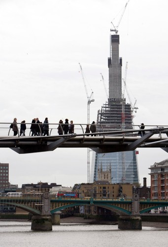 Listopad 2010. Przechodnie zerkają na rosnący wieżowiec z Mostu Milenijnego.