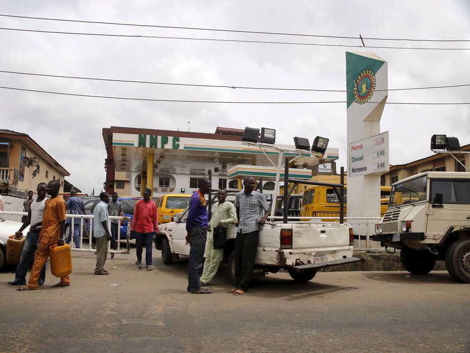People line up with their vehicles to buy fuel in front of a station at in Lagos on April 5, 2016.