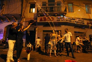 People react to a giant soap bubble during a music festival in Mar Mikhael area in Beirut