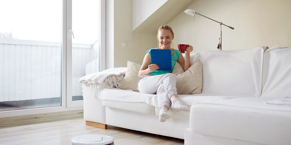 happy woman with tablet pc drinking tea at home