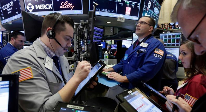 Traders gather on the floor of the New York Stock Exchange, Friday, March 18, 2016.