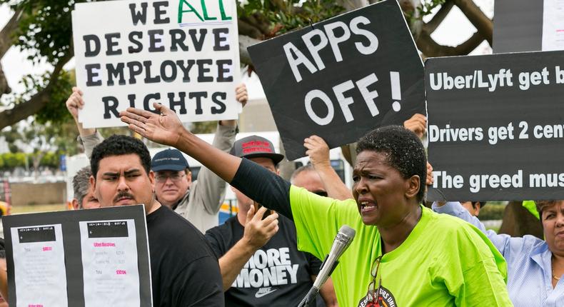 Uber driver Estaphanie St. Just joins drivers for ride-hailing giants Uber and Lyft, as they hold a rally at a park near Los Angeles International Airport, Wednesday, May, 8, 2019, in Los Angeles.AP Photo/Damian Dovarganes