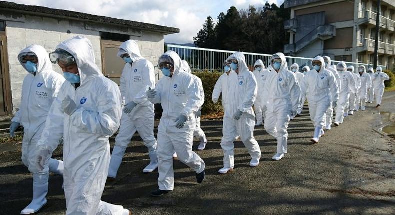 Wearing anti-virus suits, soldiers of Japan's Ground Self Defense Force head to a chicken farm in Sekikawa, Niigata prefecture, on November 29, 2016