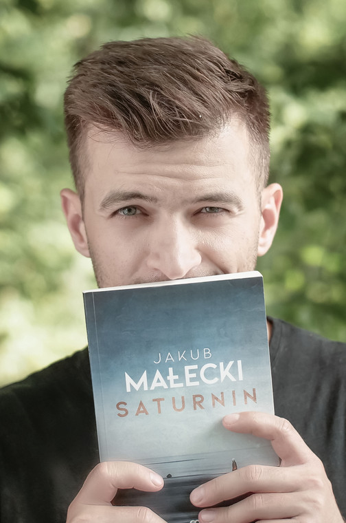 Jakub Małecki z książką "Saturnin"