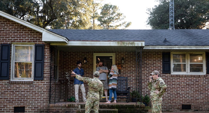 Airmen from Joint Base Charleston speak to a family living right next to the site of a crashed F-35 about the operation to recover the fighter jet and requests for the family in Williamsburg County, S.C., on Monday, Sept. 18, 2023.Henry Taylor/The Post And Courier via AP