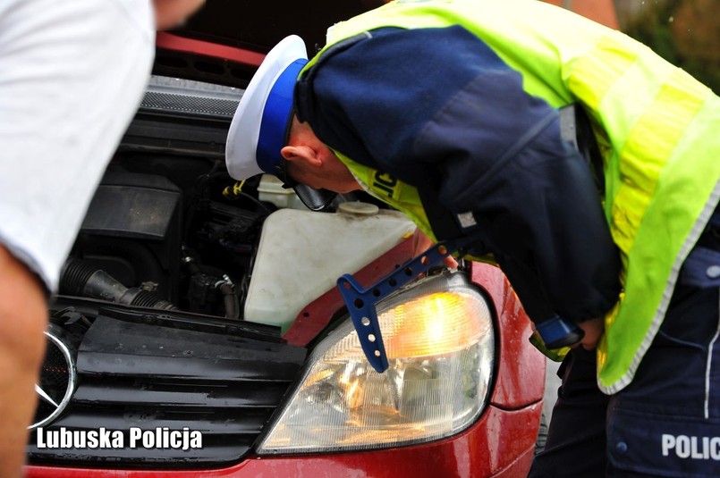 Policjant kontroluje stan techniczny oświetlenia