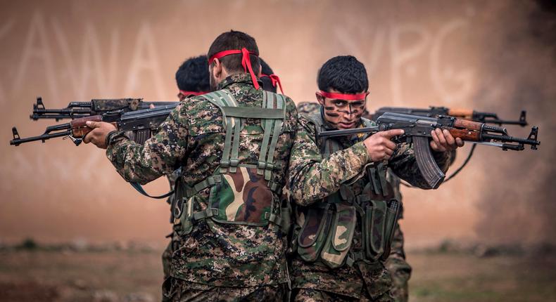 Fighters of the Kurdish People's Protection Units (YPG) carry their weapons at a military training camp in Ras al-Ain February 13, 2015.