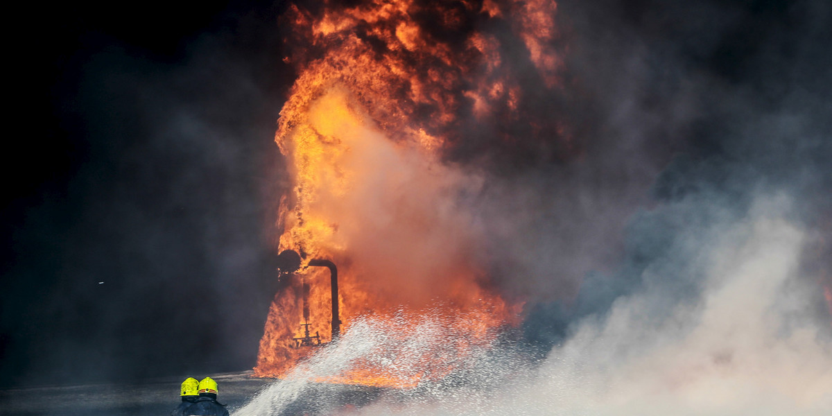 Firefighters try to put out the fire in an oil tank in the port of Es Sider, in Ras Lanuf, Libya, after an ISIS attack.