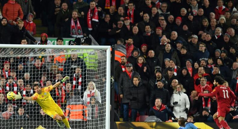 A Mohamed Salah (R) header beats Manchester City goalkeeper Claudio Bravo to give Liverpool a two-goal lead in an English Premier League clash at Anfield