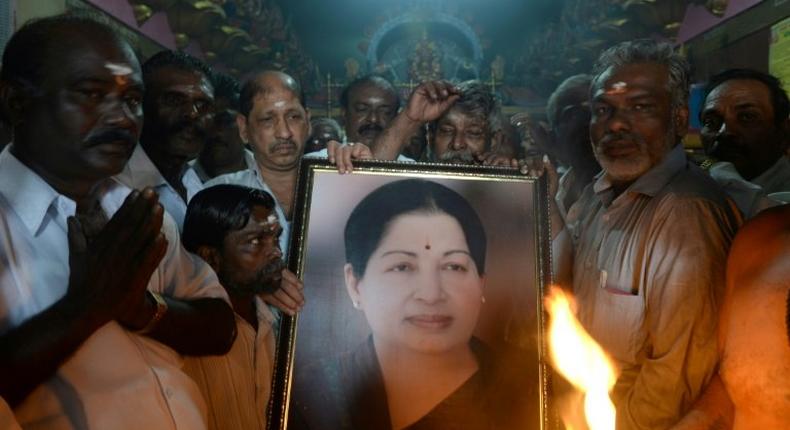 Supporters hold a photograph of Tamil Nadu state leader Jayalalithaa Jayaram as they offer prayers for her well being at a temple in Mumbai on December 5, 2016