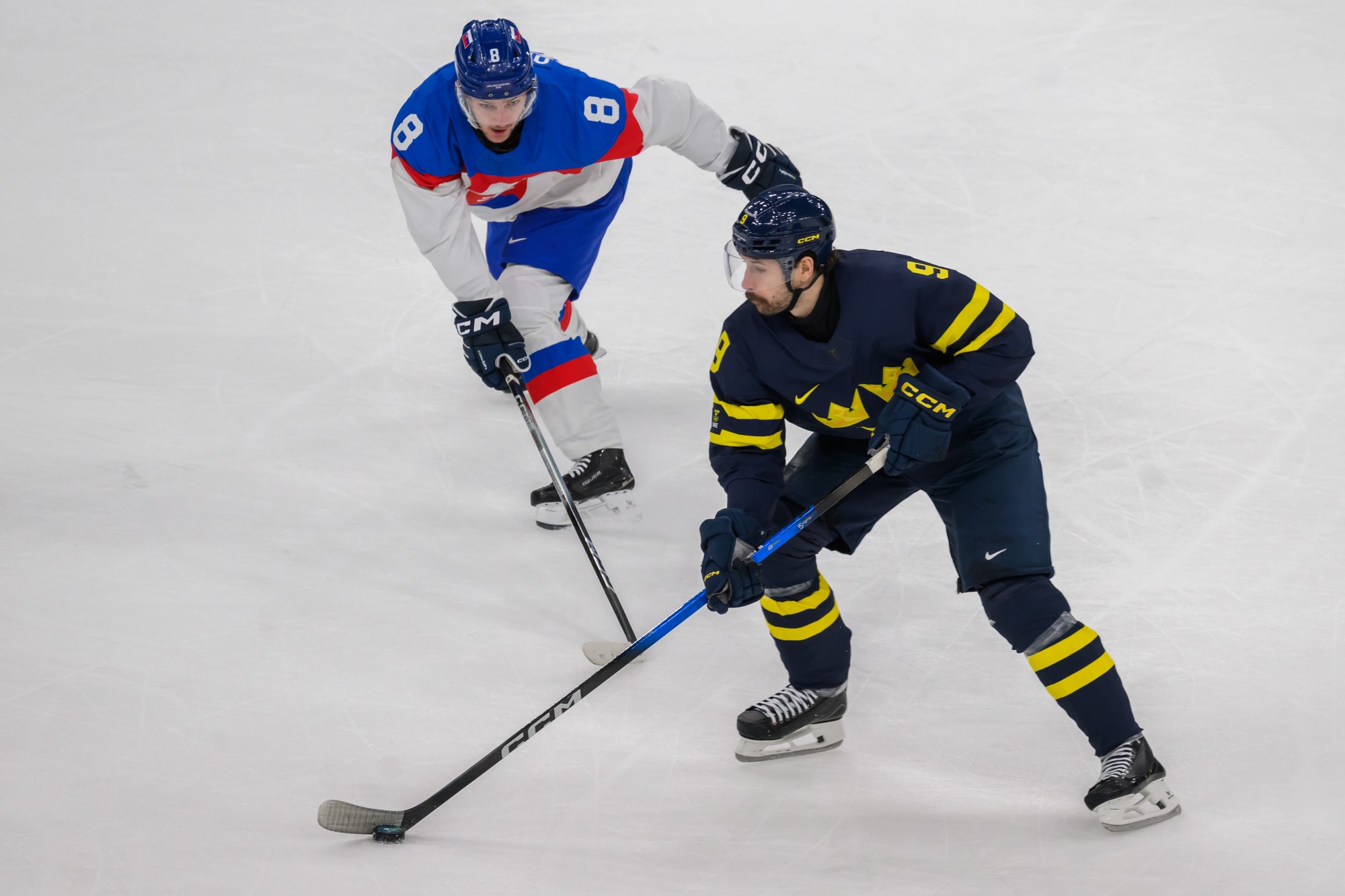 Zľava Oliver Okuliar (Slovensko) a Filip Forsberg (Švédsko) bojujú o puk. 