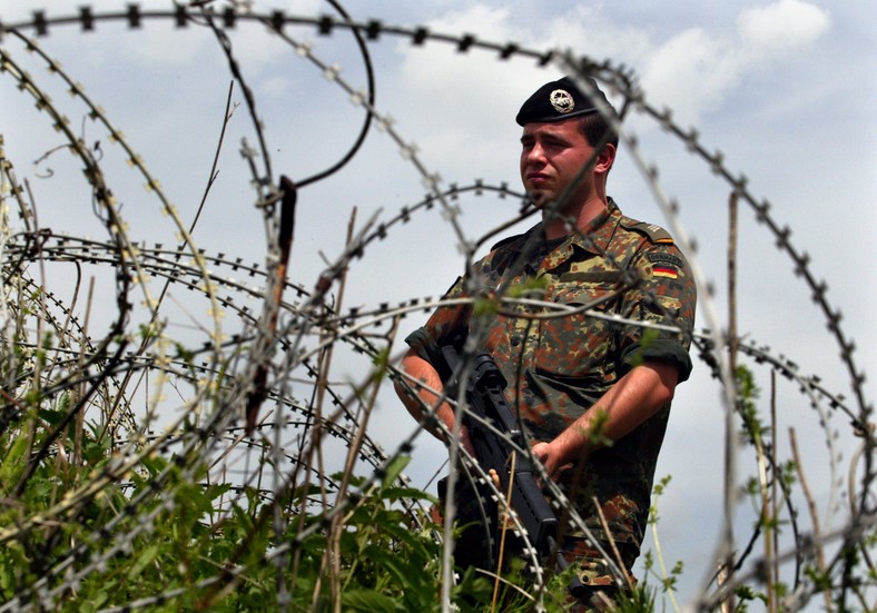 Niemiecki żołnierz, służący w dowodzonych przez NATO Siłach Stabilizacyjnych (SFOR) stoi na straży przed niemiecką bazą w Sarajewie (2002 r.)