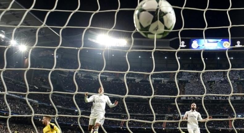 Real Madrid's goalkeeper Keylor Navas (2ndR) looks at the ball after Dortmund's midfielder Marco Reus' goal (L) during the UEFA Champions League football match Real Madrid CF vs Borussia Dortmund at the Santiago Bernabeu stadium on December 7, 2016