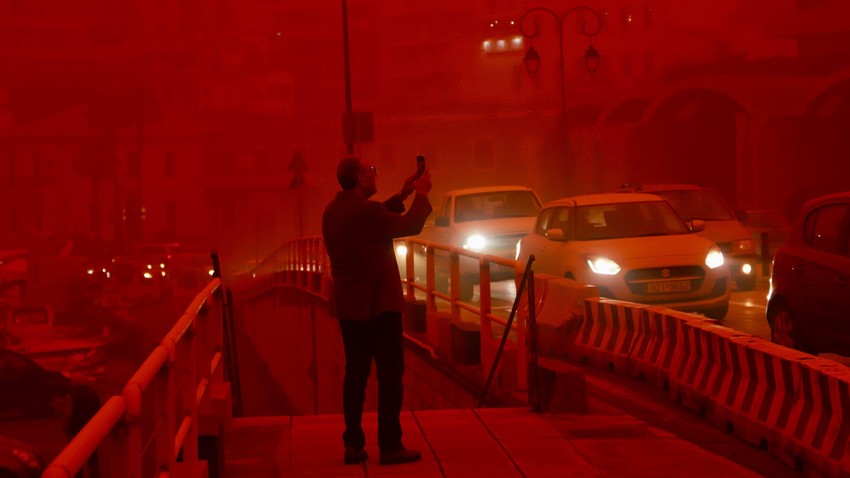 Čovek fotografiše grad Iraklion prekriven crvenom prašinom pristiglom iz Afrike | Foto: NIKOS CHALKIADAKIS/EPA/Shutterstock