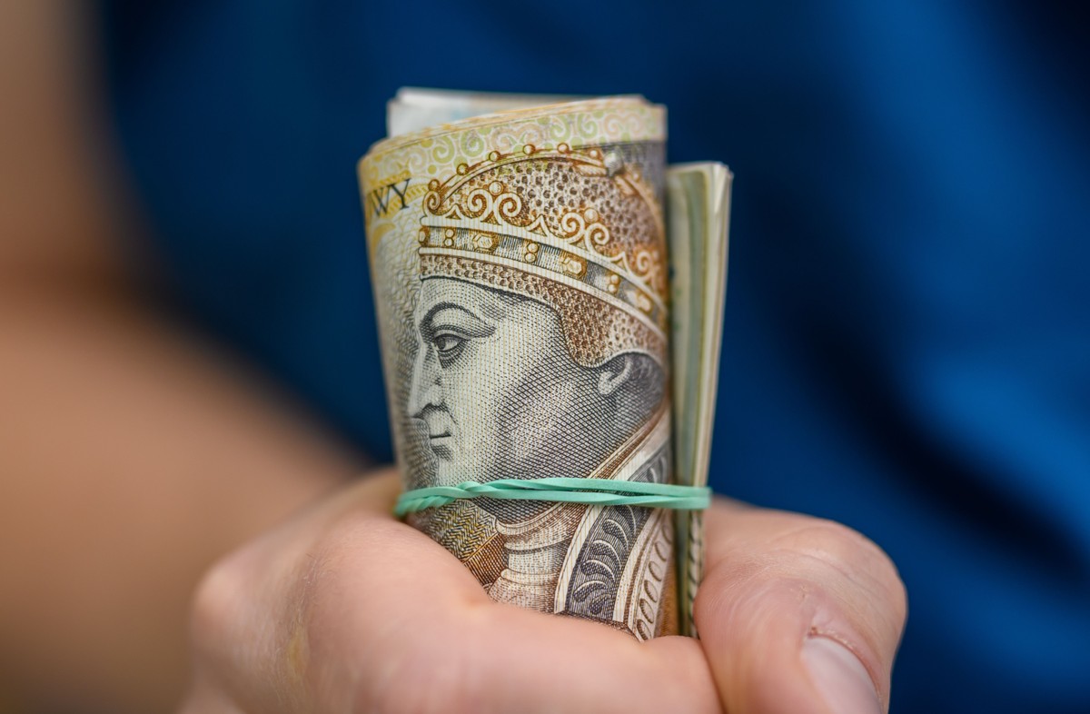 Plik pieniędzy 200 złotowych zawinięty w rulon ograniczony gumką