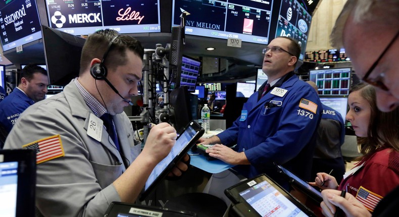 Traders gather on the floor of the New York Stock Exchange, Friday, March 18, 2016.