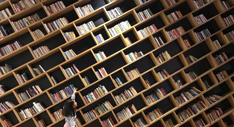 A child reaching up to grab a book from a shelf.Hasret Sonmez/Getty Images