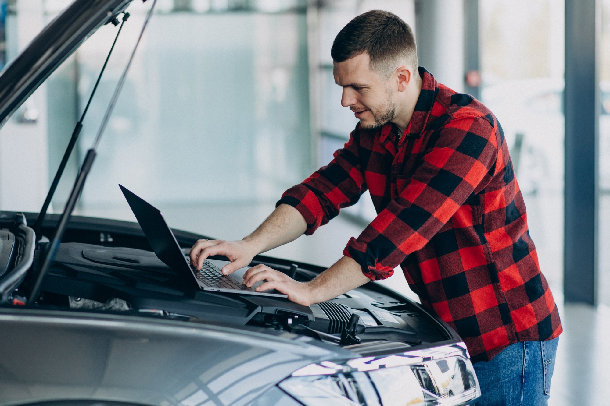 Mechanik pri práci na aute – vyššie náklady na prácu zvyšujú cenu opráv. 