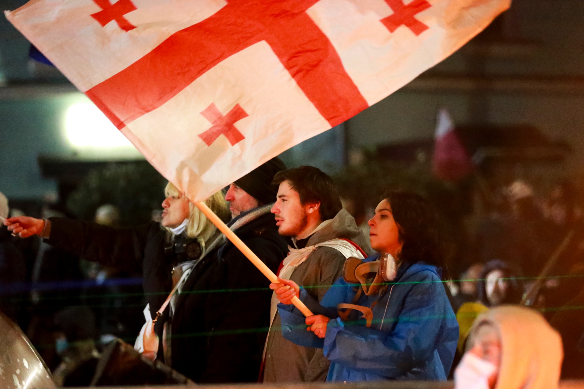 Demonštrantka drží gruzínsku vlajku počas zhromaždenia pred parlamentom na protest proti rozhodnutiu vlády pozastaviť rokovania o vstupe do Európskej únie na štyri roky.