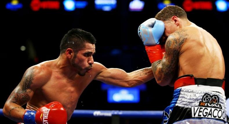 Jesus Cuellar (L) of Argentina punches Jonathan Oquendo of Puerto Rico during their WBA Featherweight Championship bout on December 5, 2015 in New York City