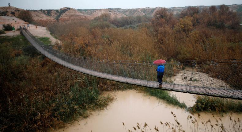 A man walks on a bridge crossing over the Besor stream on a rainy day, near Kibbutz Tze'elim in Israel's southern Negev desert.