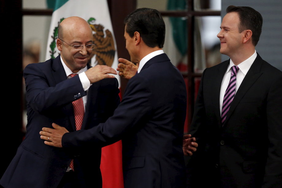Mexico's President Enrique Pena Nieto, center, hugs Renato Sales, left, the new National Security Commissioner, during the official swearing-in ceremony of new ministers at Los Pinos presidential residence in Mexico City, August 27, 2015.