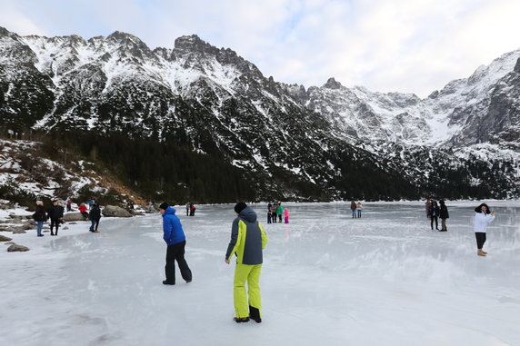 Turyści na tafli lodu na jeziorze Morskie Oko w Tatrach