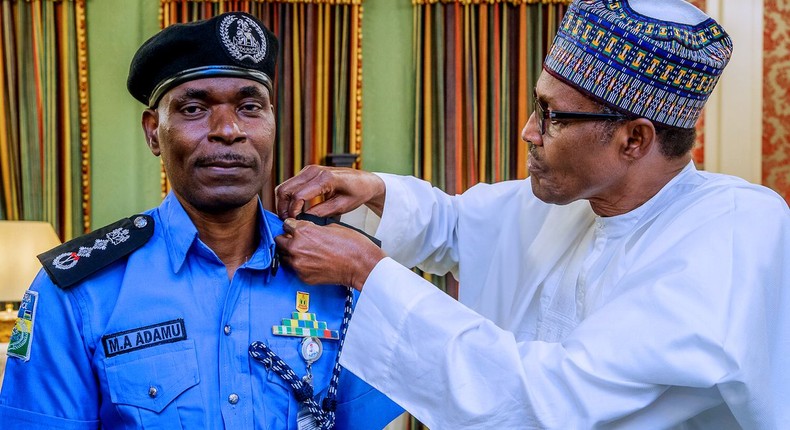 President Muhammadu Buhari decorates Mohammed Adamu as the new Inspector-General of Police [Twitter/@NGRPresident]