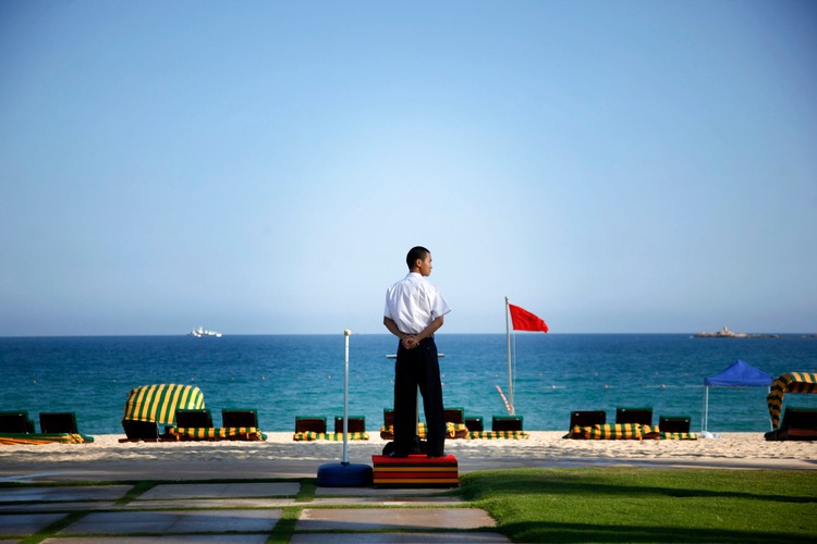 Członek ochrony patroluje plażę w Sanya w Chinach