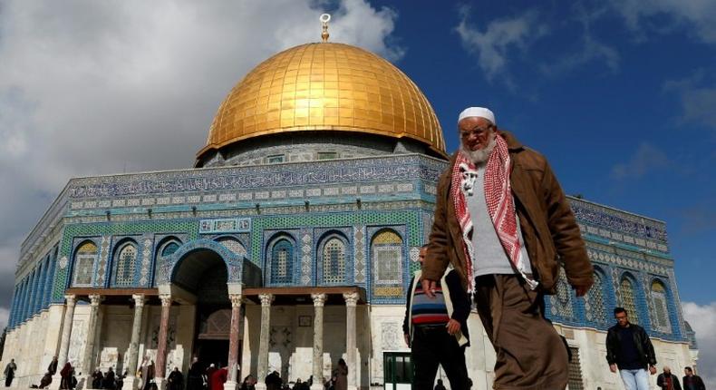 Palestinians walk past the Dome of Rock at the Al-Aqsa Mosque compound in Jerusalem's Old City, on January 13, 2017