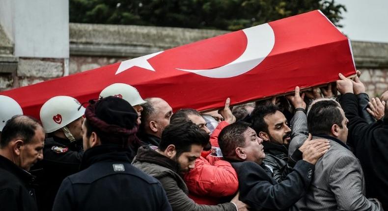 Mourners carry the coffin of a Turkish police officer killed in weekend bombings in Istanbul, on December 12, 2016