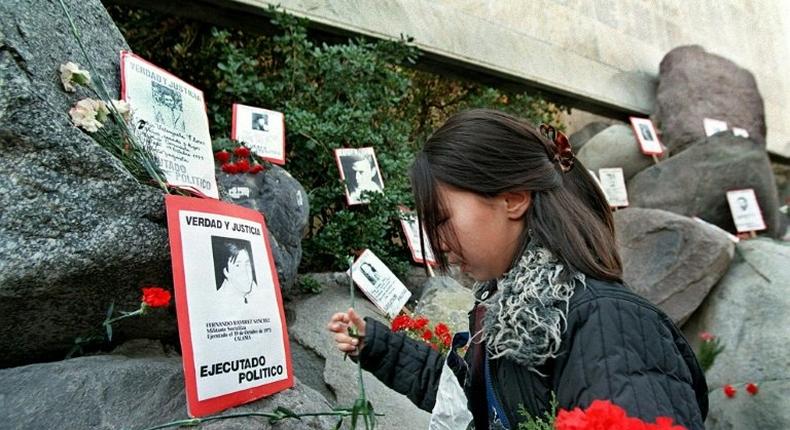 A relative of the Caravan of Death incident places flowers in the Memorial to the Detained and Disappeared at the Santiago cemetery, on July 21, 1999