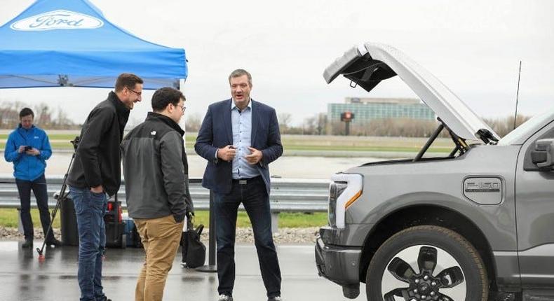 Darren Palmer speaks with customers in front of a Ford F-150 Lightning.Ford