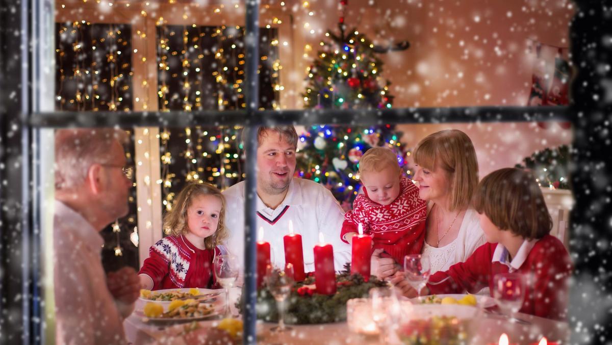 Family enjoying Christmas dinner at home in decorated room