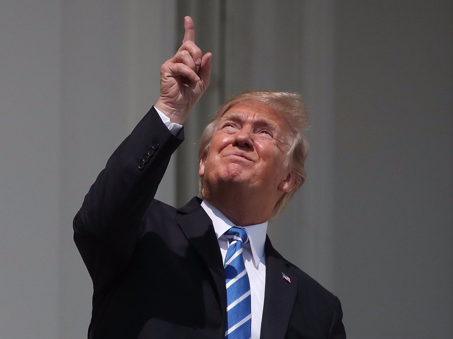 Trump pointing toward the sky during the solar eclipse in August.