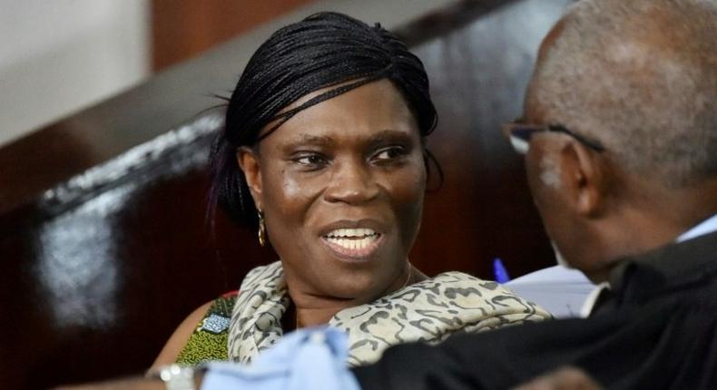 Former Ivorian first lady Simone Gbagbo (L) talks to her lawyer at the Abidjan's courthouse on October 10, 2016 before the re-opening of her trial, during which she was prevented from leaving the courtroom by military police November 29, 2016